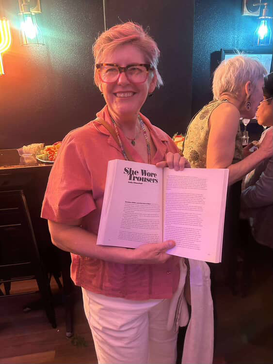 Sally holds a copy of Queersland open to her story at the launch.