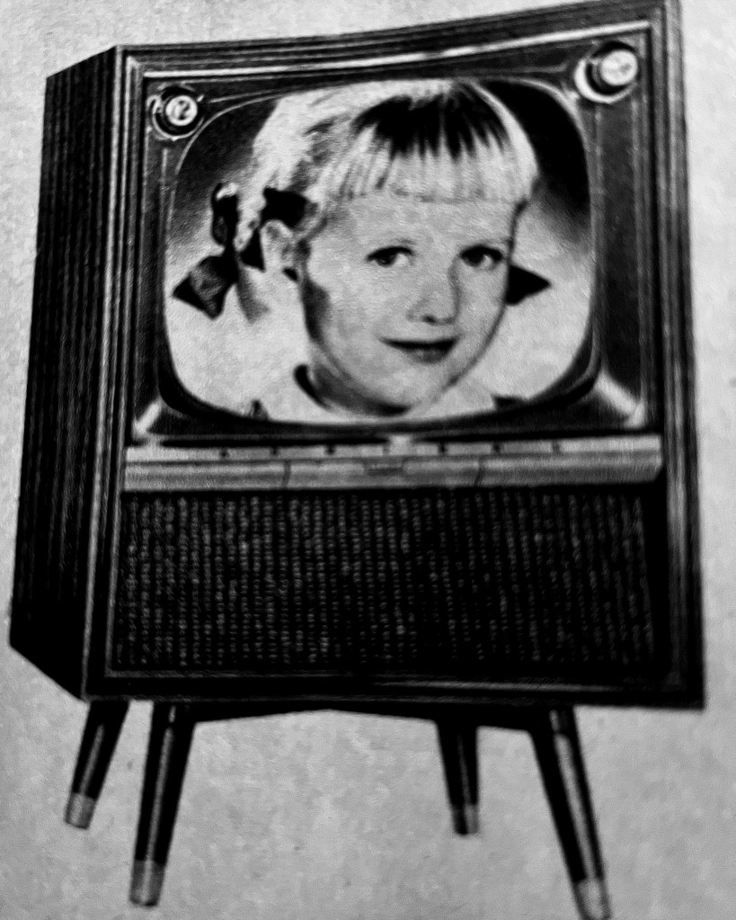 a little blonde girl on an old fashioned TV set
